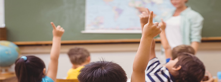 Niños levantando la mano en una sala de clases